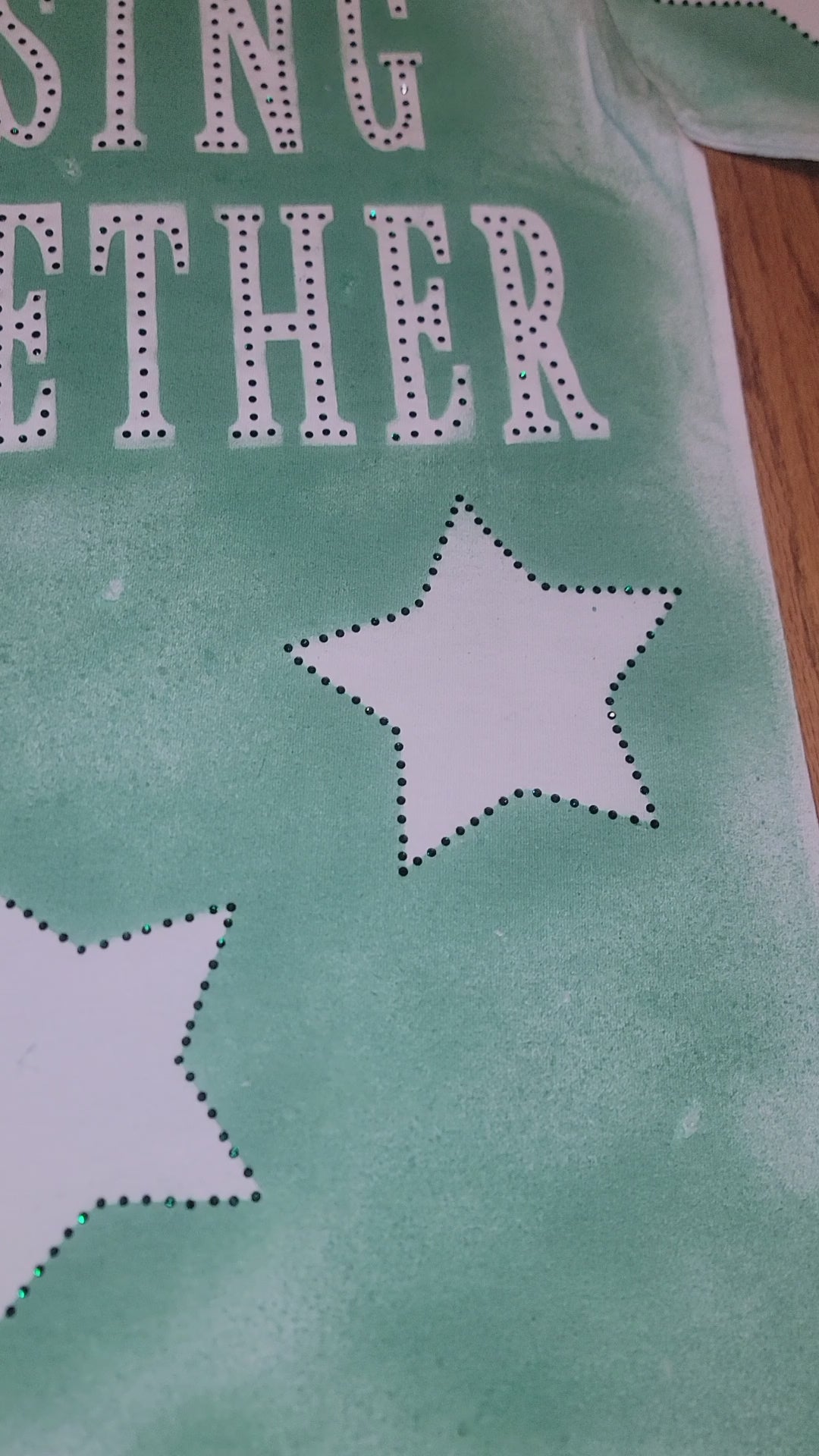 RISING STAR FABRIC-PAINTED TEE fabric design featuring green background and dotted stars.